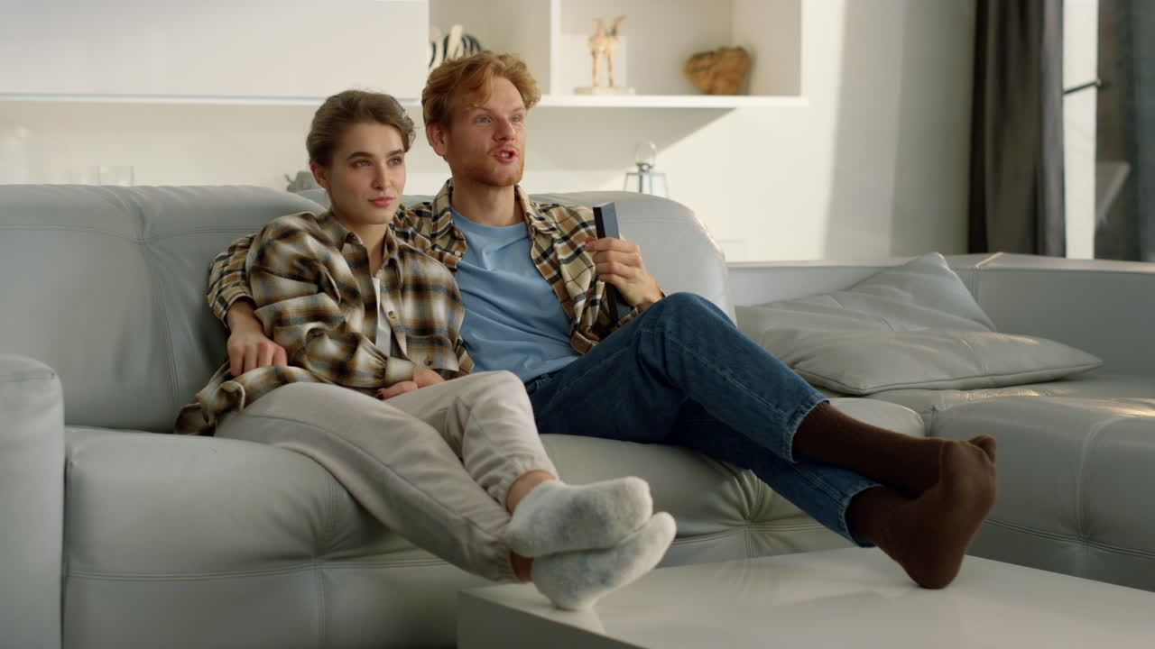 una pareja casada disfruta de una noche de televisión en casa. una familia feliz discute en un programa.