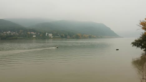 Luftaufnahme-Der-Donau-Von-Pilismarót,-Zebegény,-Ungarn-Im-Hintergrund-Mit-Einem-Motorboot,-Das-Den-Fluss-überquert