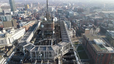 Luftdrohnenflug-über-Dem-Dach-Des-Stadtturms-In-Manchester-Piccadilly-Gardens,-Der-Die-Gebäude-Unten-Zeigt