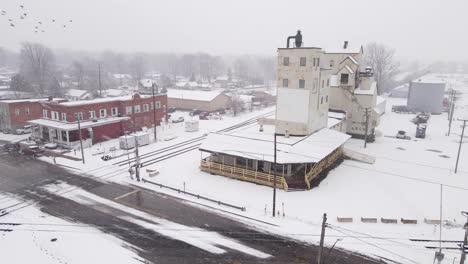 Industrial-building-of-grain-near-train-station-in-small-USA-town,-aerial-view