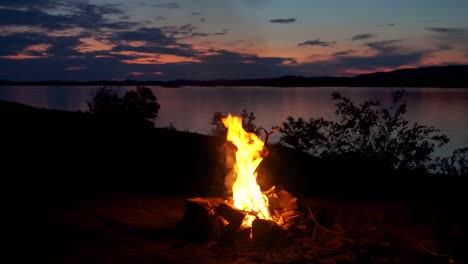 campfire by a lake at dusk