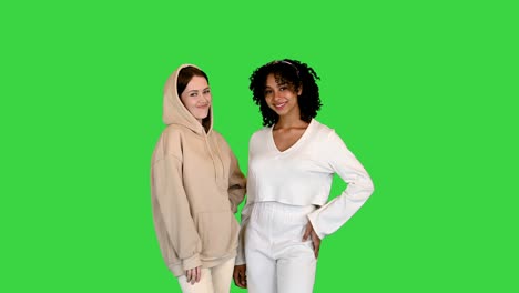 two mixed race girls looking into the camera on a green screen, chroma key