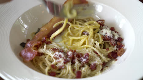 fork rolling carbonara spaghetti with egg