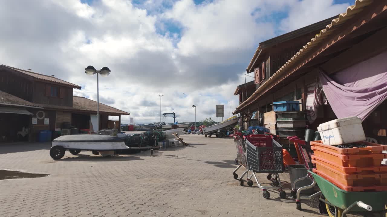 Fishing harbour in Alvor, Portugal, showing boats, carts, and warehouses