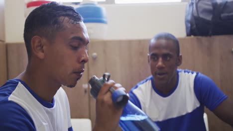 soccer player drinking water in the locker room