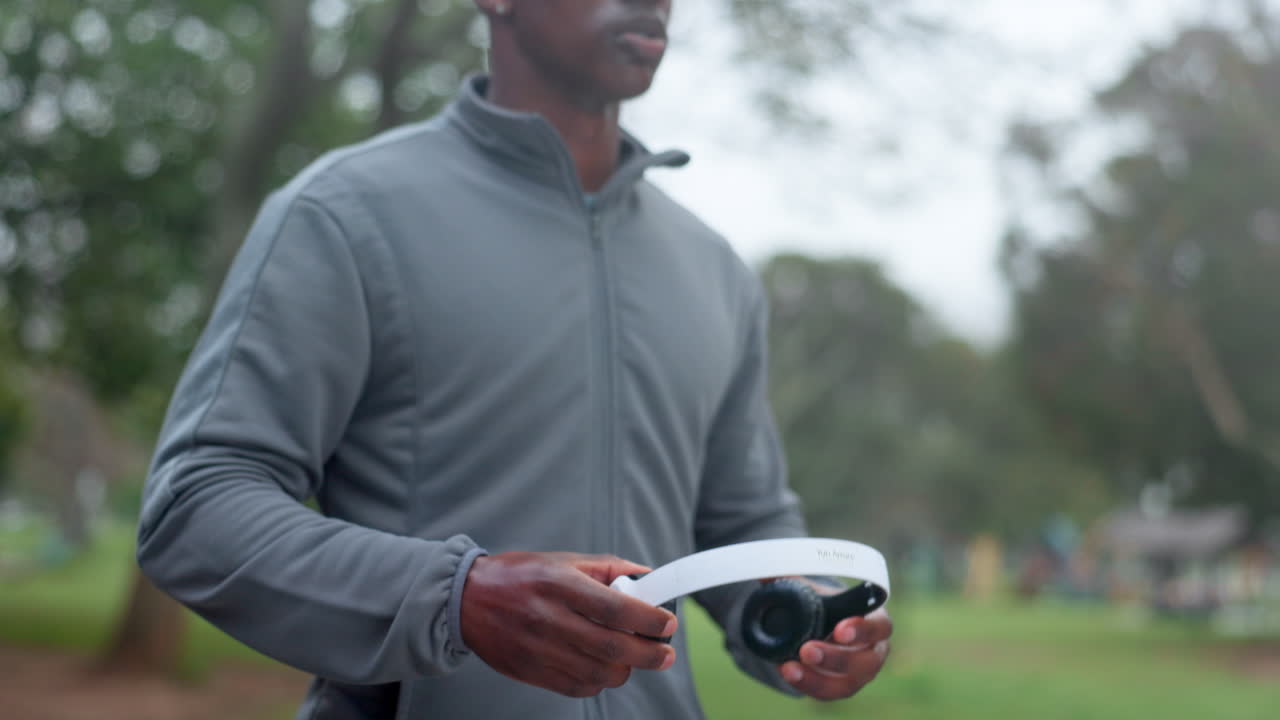 헤드폰을 들고 공원에서 달리는 남자