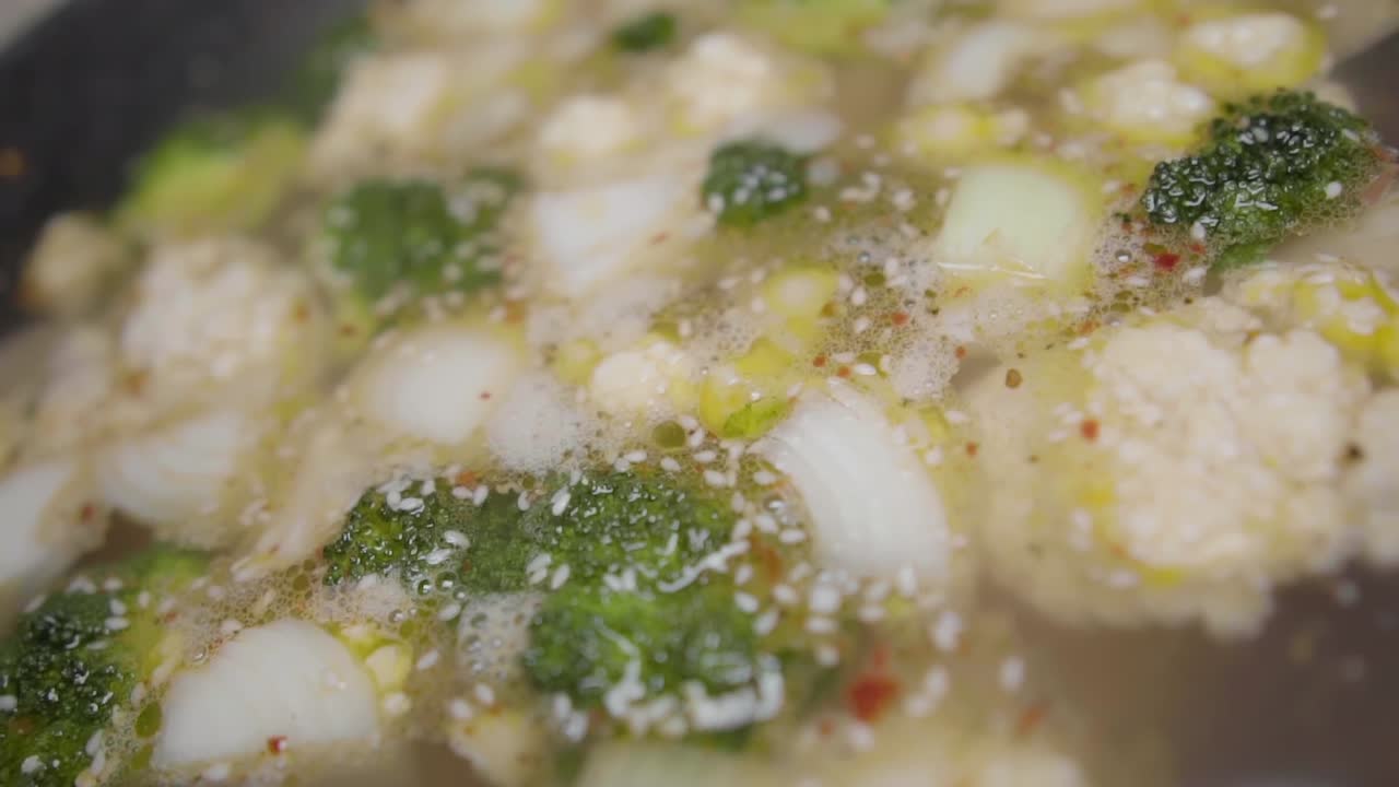 큰 냄비에 국물에 요리하는 슬로우 모션 다진 야채 회전