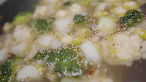 verduras picadas en movimiento lento cocinadas en caldo en una olla grande