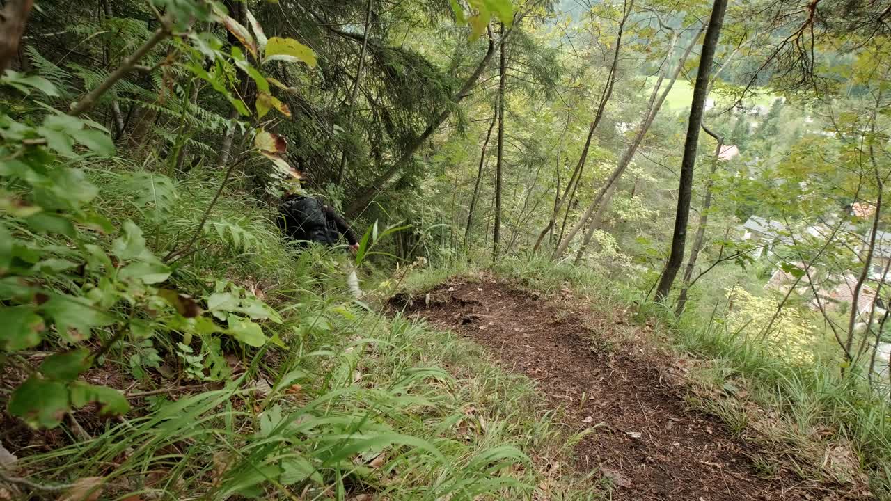 un hombre caminando por un bosque muy verde en un día nublado en eslovenia ubicado cerca del pueblo de gozd martuljek-3