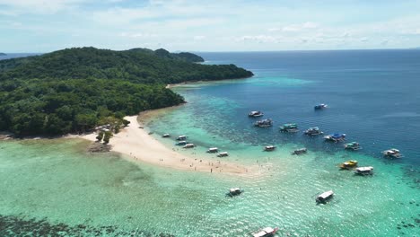 una isla tropical es un paraíso de playas con barcos y turistas.