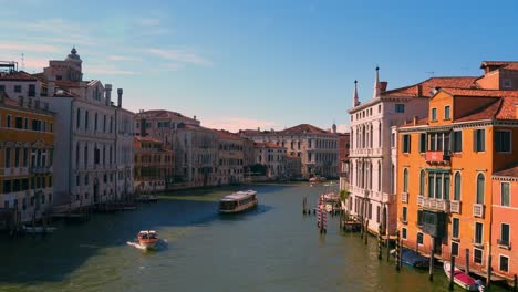 Grand-canal,-Canale-Grande-in-Venice,-Italy-with-a-boat-and-gondola,-old-houses-and-a-cathedral-church-close-to-San-Marco-and-Rialto-Bridge