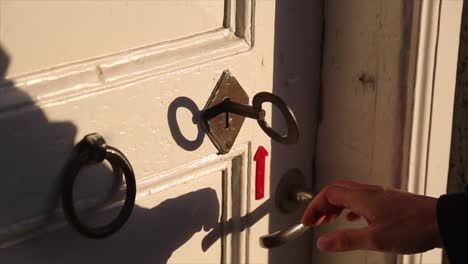 man opening a lock with an old key