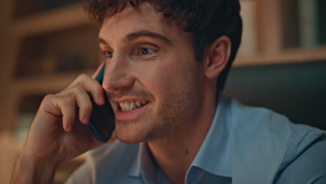 Closeup businessman talking mobile phone at evening office. Smiling man calling