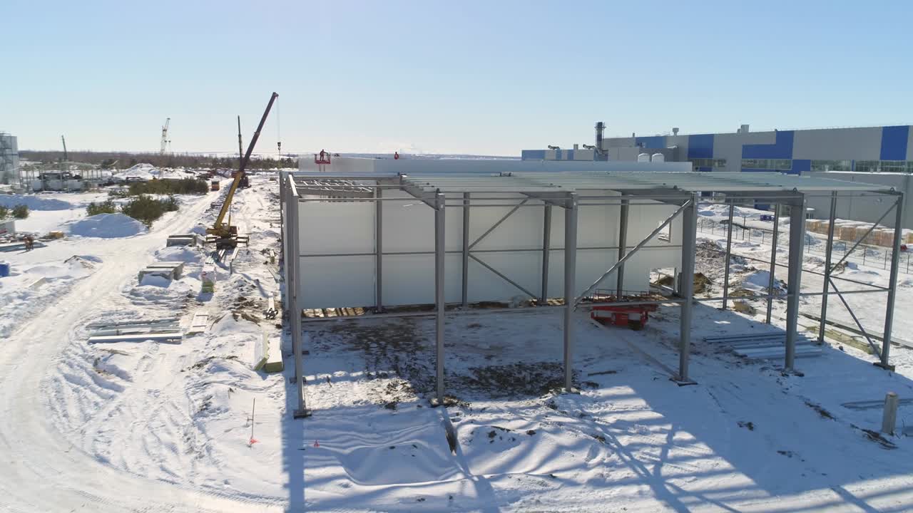 ножничный лифт в незавершенном здании мастерской на заснеженном месте