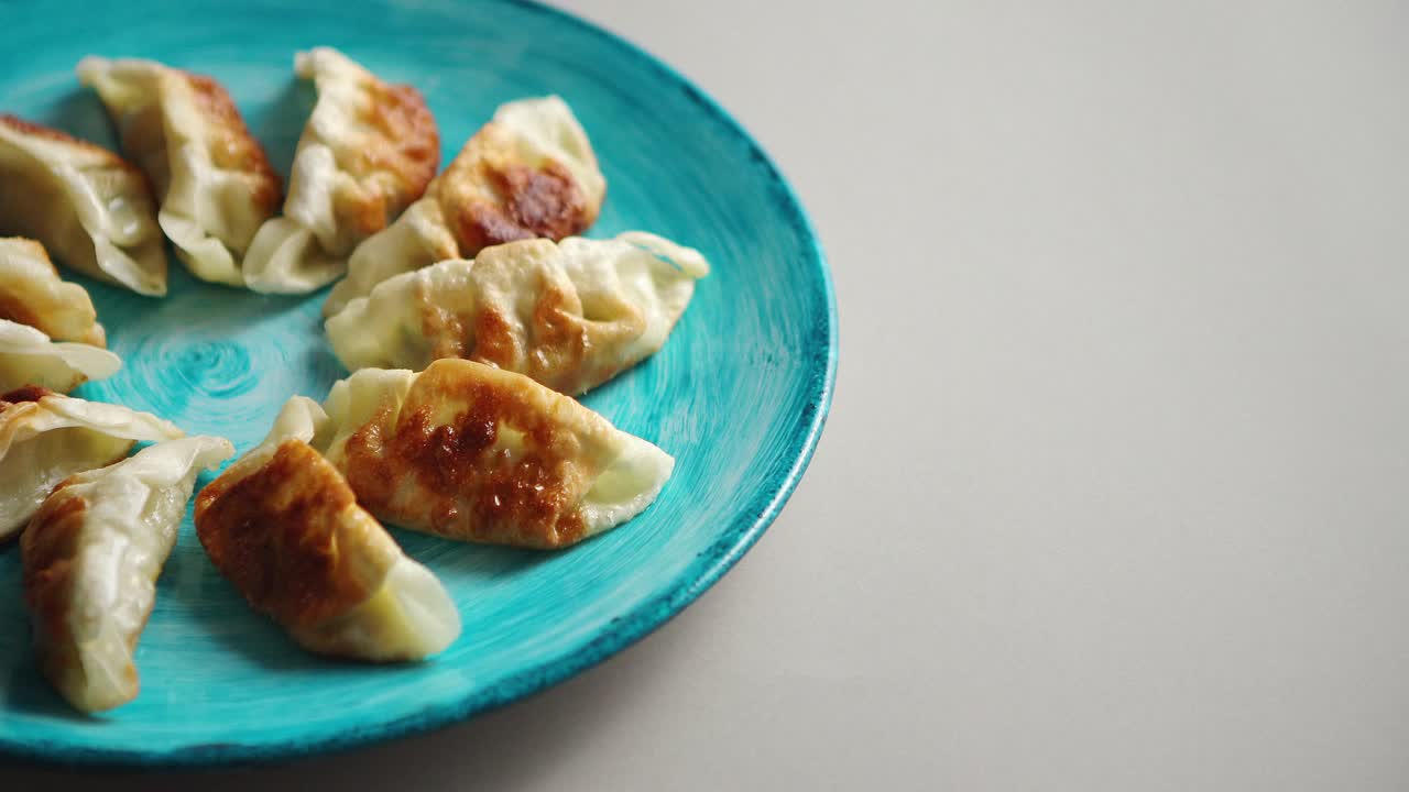 albóndigas asiáticas tradicionales gyozas en plato de cerámica turquesa
