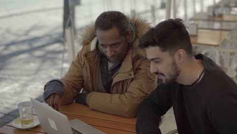 focused freelancers working with laptop in cafe