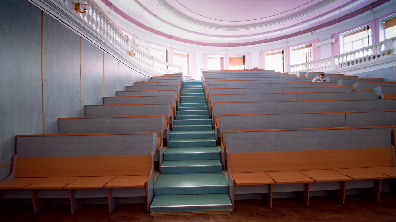 Wooden benches inside auditorium. Lecture chairs in class room with stair path in the middle of class