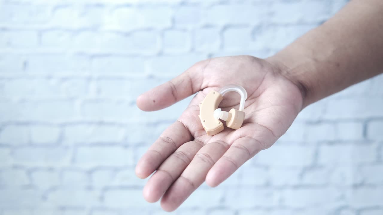 손에 청각 장비를 들고 있는 사람