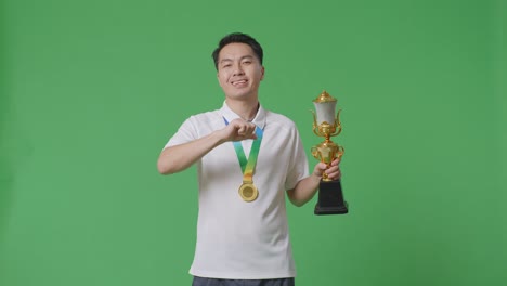 man celebrating a victory with trophy and medal