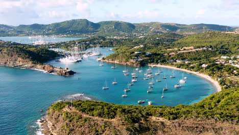 Sonnige-Luftaufnahme-Des-Englischen-Hafens-In-Antigua,-Karibik-Mit-Blick-Auf-Yachten,-Segelboote,-Marina,-Bucht-Und-Klippen