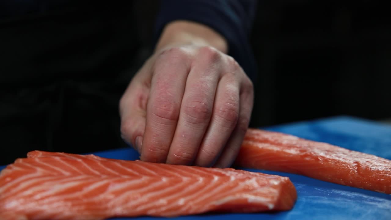 셰프가 연어 사시미를 준비하고 있습니다.