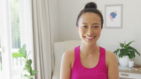 Portrait-of-happy-asian-woman-looking-at-camera-and-smiling-in-bedroom,-in-slow-motion