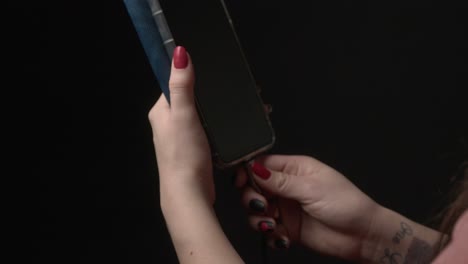 Checking Battery Life – Woman Plugs in Phone to Recharge