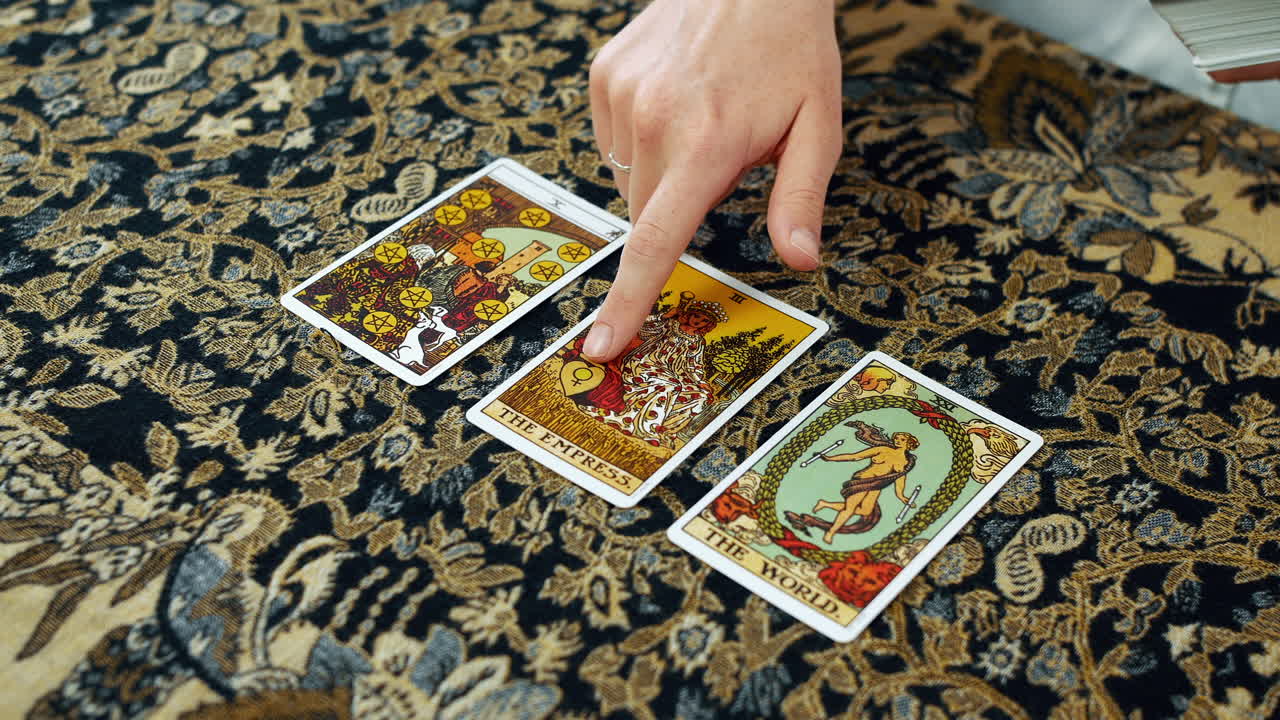 una mujer dando una lectura del tarot con diez de pentáculos la emperatriz y las cartas del mundo