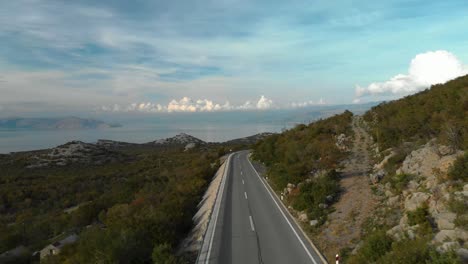 Aerial-drone-shot-over-car-road-located-near-sea-1