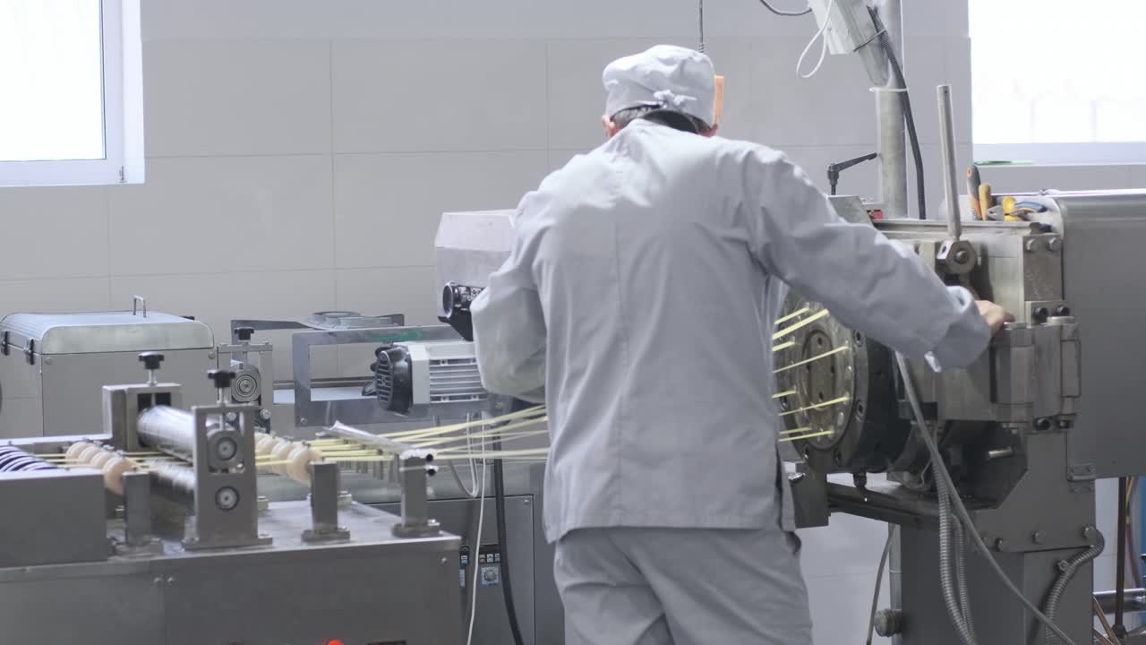 Production factory line moves golden potato chips after frying, slow motion. Production line of the pasta factory
