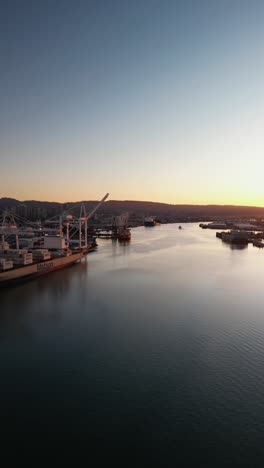 a sunrise drone shot looking down at the oakland inner harbor, revealing piers, boats, and industrial areas.