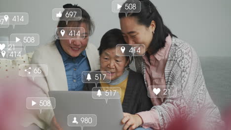 animation of social media notifications over happy asian female relatives using laptop at home