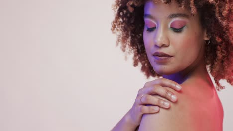 Biracial-woman-with-dark-hair-in-blue-and-pink-light-with-copy-space,-slow-motion