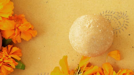 pan across indian sweets, flowers, diyas on a indian background for hindu festival of lights, dusshera and diwali preparation and celebration ingredients