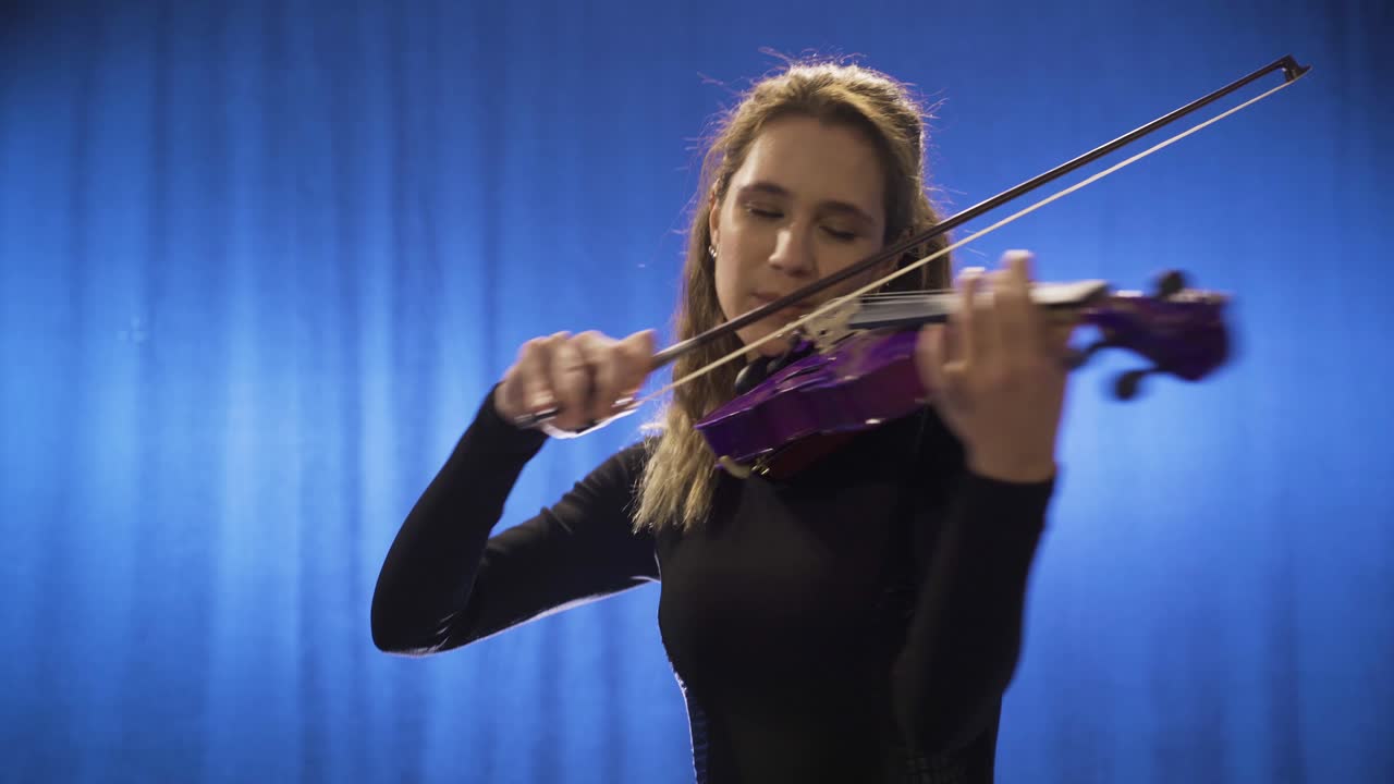 músico femenino tocando el violín sonriendo y feliz cantante de ópera maestra de música.
