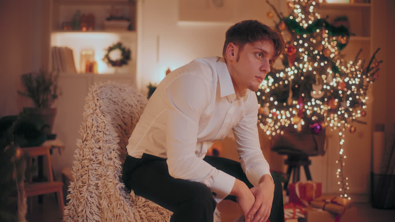 hombre deprimido sosteniendo el sombrero de papá noel mientras estaba sentado en una silla durante la navidad