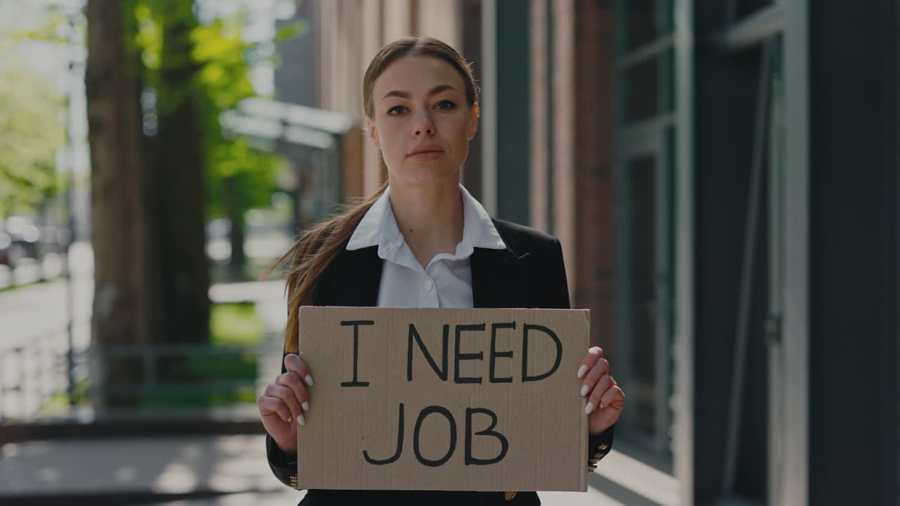 Woman holding 'I Need Job' sign