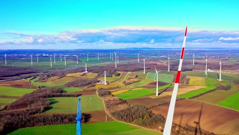 Landscape-With-Fields-And-Wind-Turbines-Under-Construction---aerial-pullback