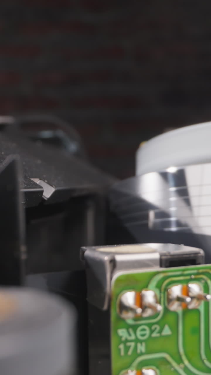 Head turns reading information from tape with moving runner in room macro view. Vintage equipment to enjoy movie at home. Electric domestic appliances