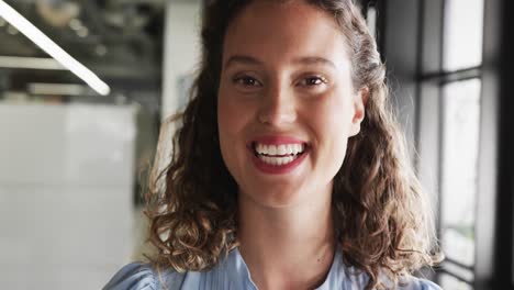 retrato de una feliz mujer de negocios caucásica en la oficina, cámara lenta