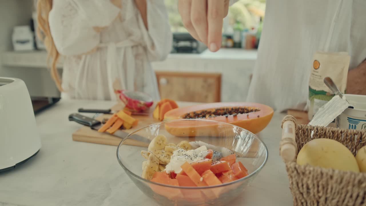 Couple preparing a healthy fruit salad breakfast