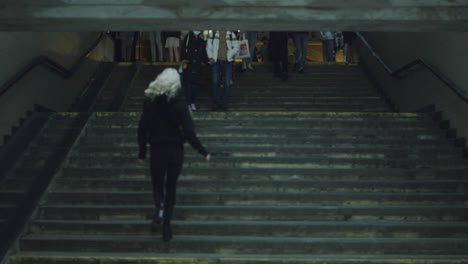 Young-woman-going-stairs-in-city-wearing-urban-wear-on-street.