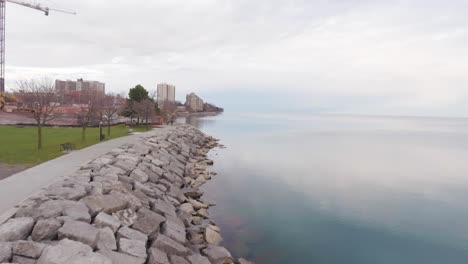 Smooth sunset aerial by the edge of the Burlington Ontario Lake. Half water half land. Five meters above sea level.