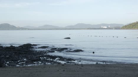 Der-Strand-Mit-Weißem-Sand-Und-Wellen-Vom-Ruhigen-Meer-Bei-Sonnenschein-Tagsüber