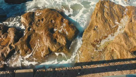 view of rocks with water splashing in manly nsw