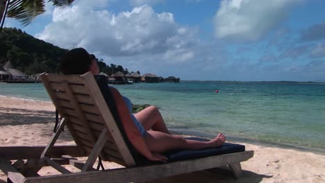 Una-Mujer-Se-Relaja-En-Una-Silla-De-Playa-En-Una-Isla-Paradisíaca-Tropical