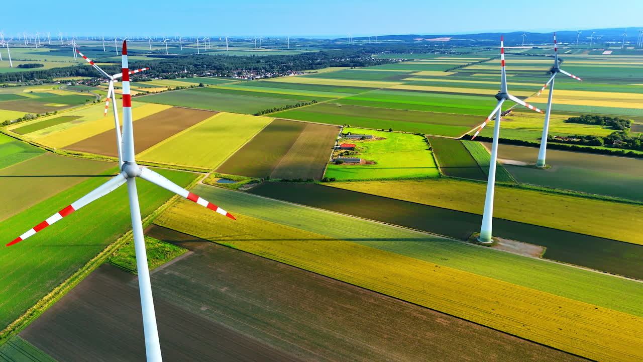 Wind turbines producing green energy. Aerial perspective on the windmills rotating in the fields.