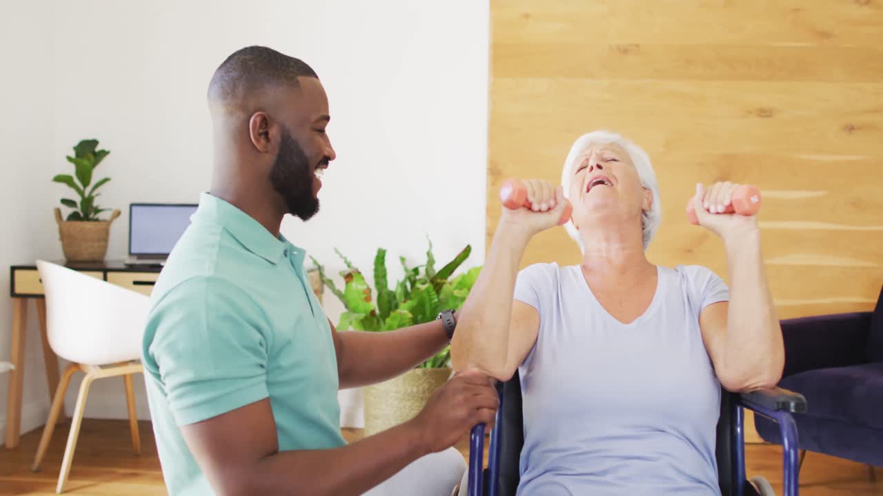 Vídeo de fisioterapeuta afro-americano feliz exercitando-se com mulher idosa caucasiana