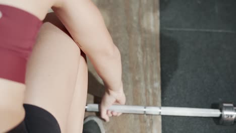 mujer levantando pesas en un gimnasio
