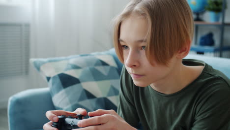 teenage boy playing video games at home